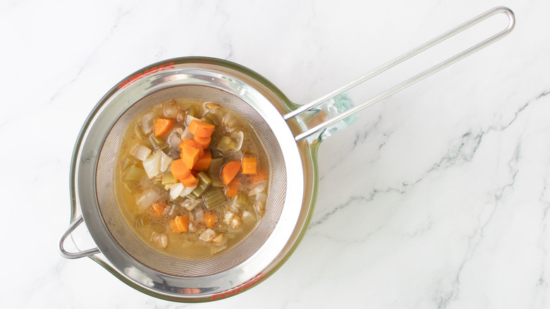 cooked vegetables in a wire mesh strainer