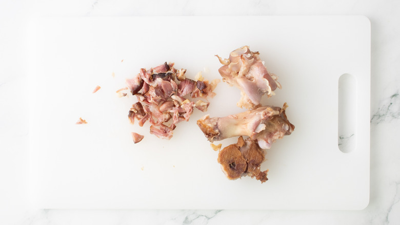 ham hock meat and bones on a white plastic board