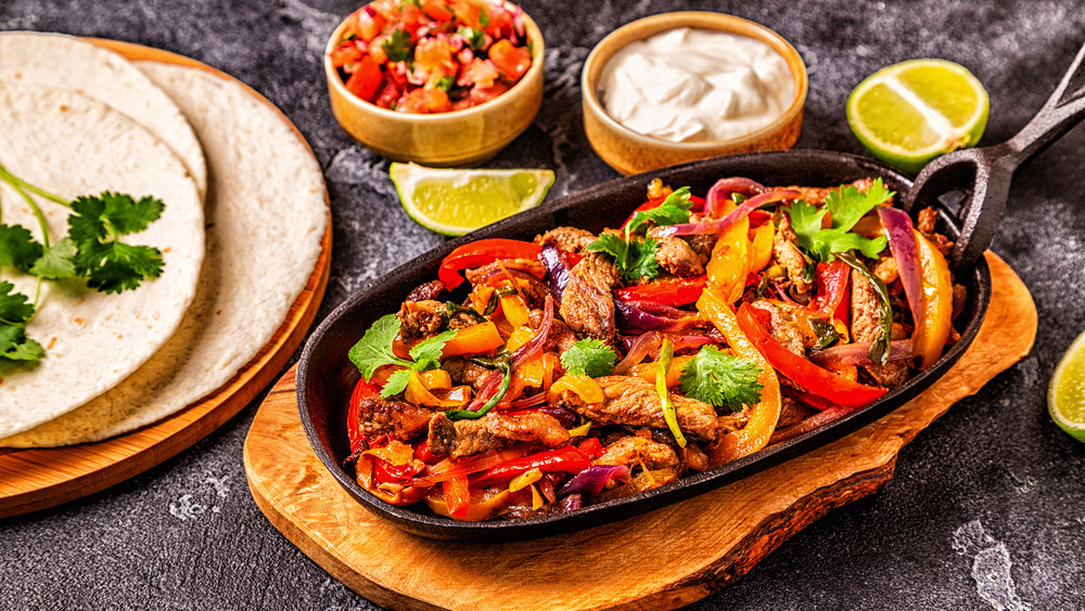 Fajitas with sour cream, salsa, and tortillas