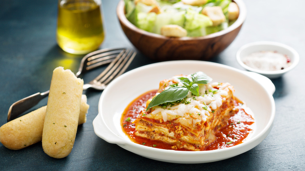 Lasagna with breadsticks and caesar salad