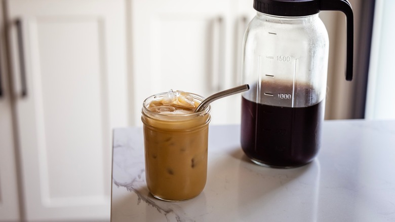 homemade cold brew in a jar on counter with pitcher of more cold brew