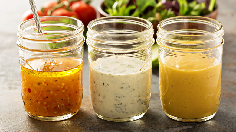 three jars of homemade salad dressing lined up