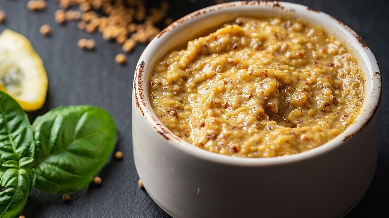 Dijon mustard in a dish with fresh basil