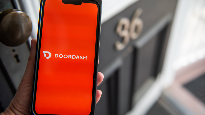 hand holds phone with doordash app