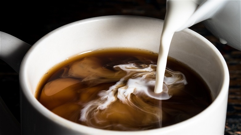 pouring cream in coffee