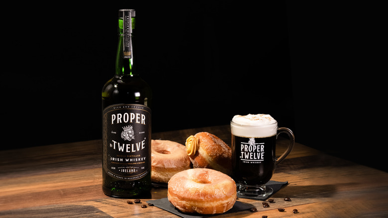 Whiskey bottle next to doughnuts