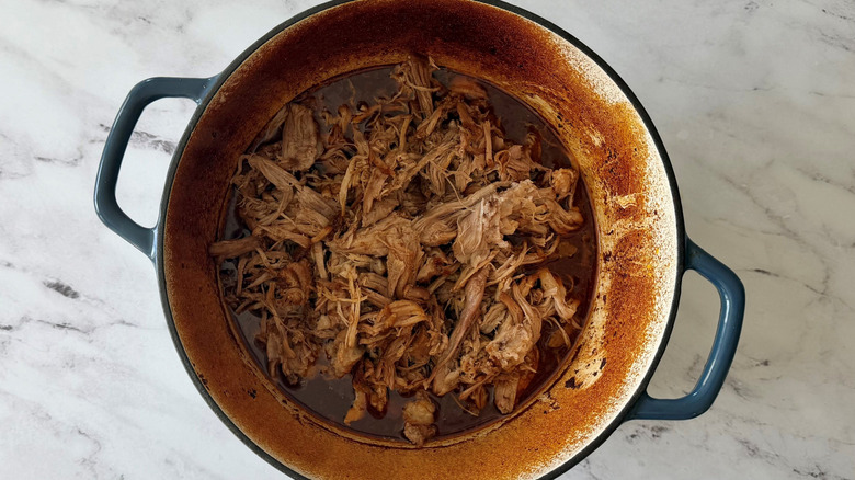 Pulled pork and braising liquid in Dutch oven