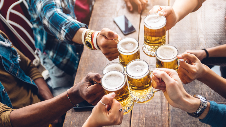 people drinking beer in mugs