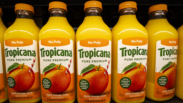 Bottles of Tropicana orange juice on grocery store shelf.