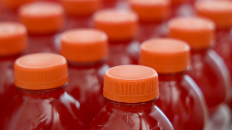 Closeup shot of red sports drink bottles with orange caps.