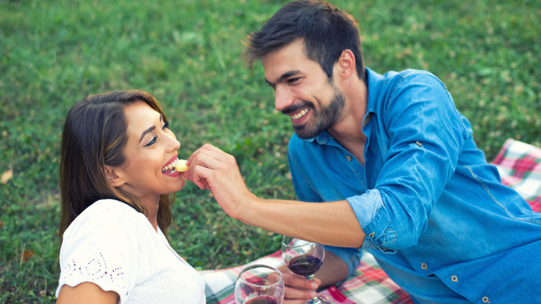 couple eating cheese with wine