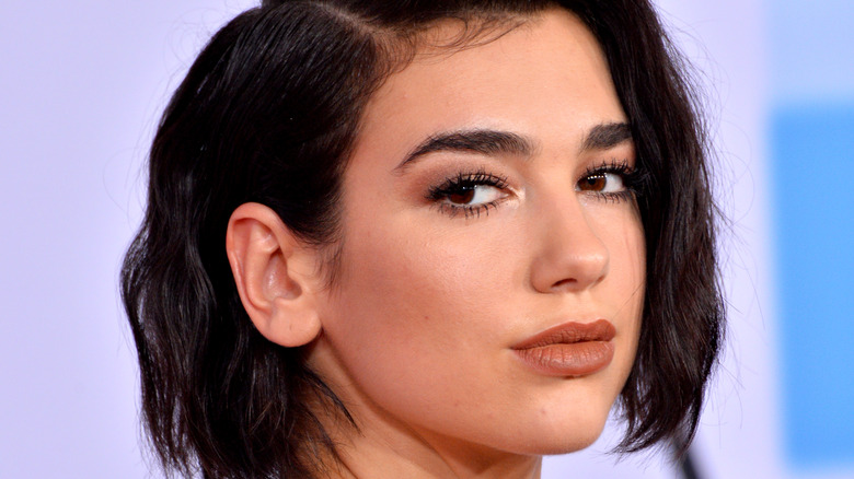 Dua Lipa looks over shoulder