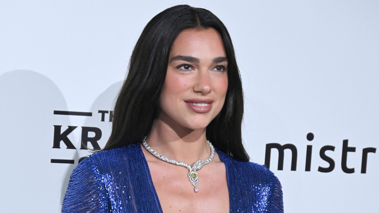Dua Lipa in a blue sequined gown with a necklace