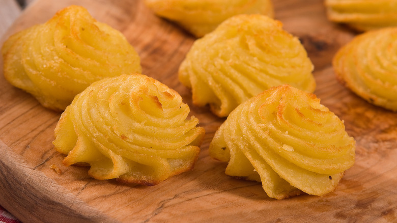 Duchess potatoes on a wooden board