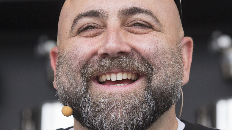 Duff Goldman smiles with a cordless microphone