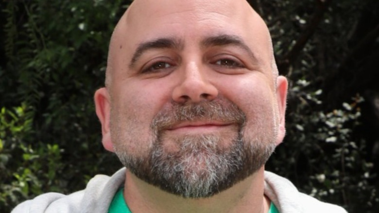 Duff Goldman smiles with gray hoodie