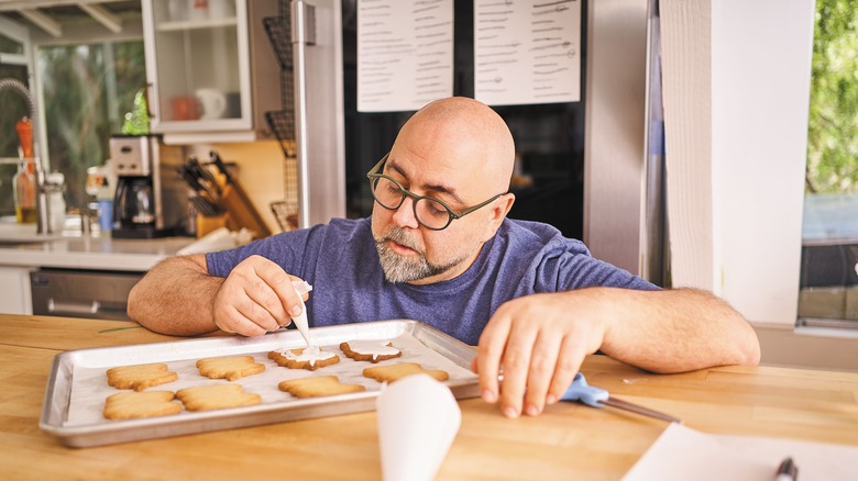 Duff Goldman decorating cookies on baking tray