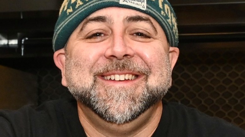 Duff Goldman with facial hair smiling in hat 