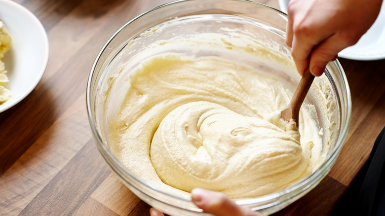 Hands stirring cake butter with spoon