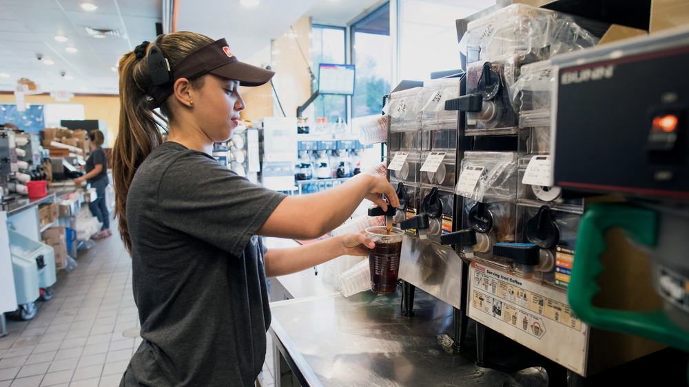 Dunkin' Donuts emplyee making a coffee