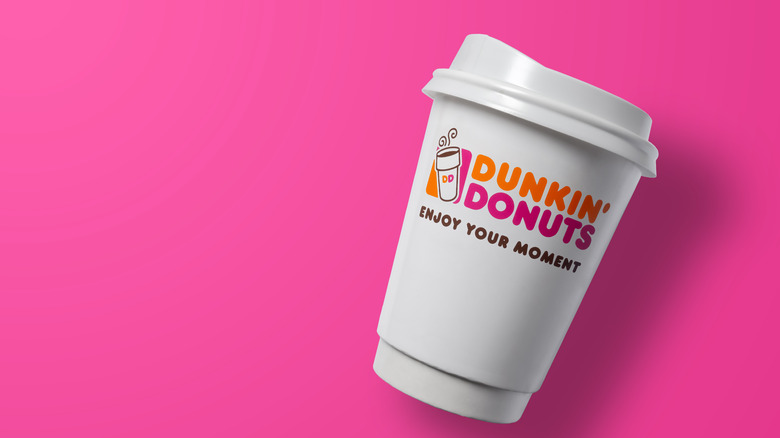 Dunkin' coffee cup against pink background