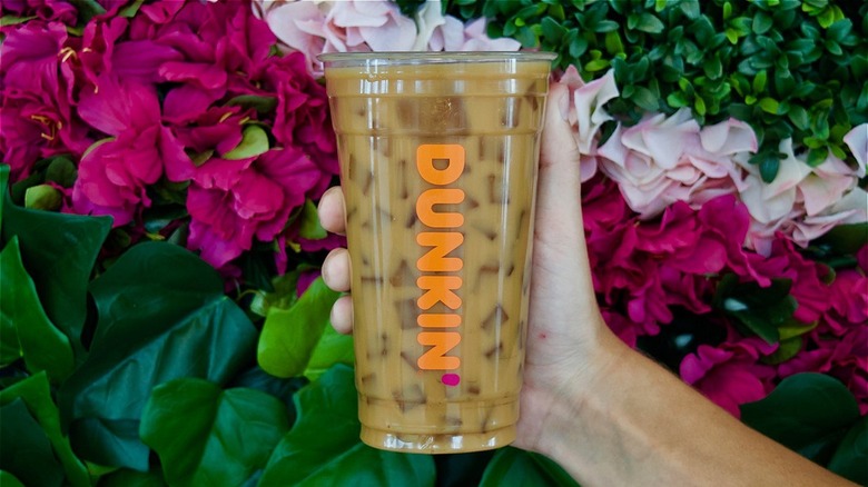 hand holding Dunkin' beverage