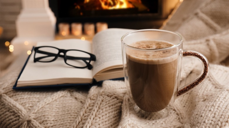 mug of hot cocoa near an open book