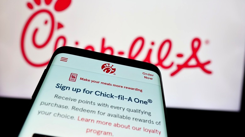 A phone displaying information on the Chick-fil-A One membership rewards program