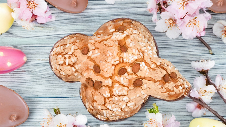Colomba di Pasqua surrounded by cherry blossoms and painted eggs