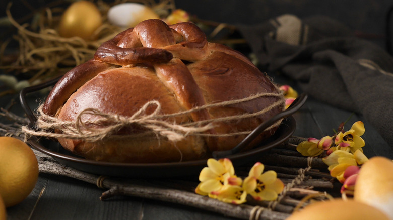 Folar da Páscoa wrapped in twine surrounded by blossoms and eggs