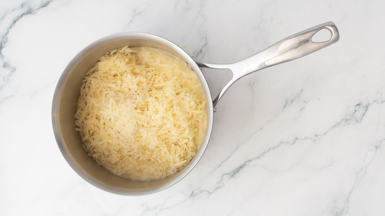 Grated cheese in saucepan