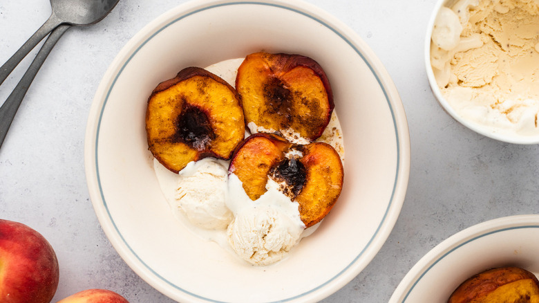 Bowl of baked peaches with ice cream