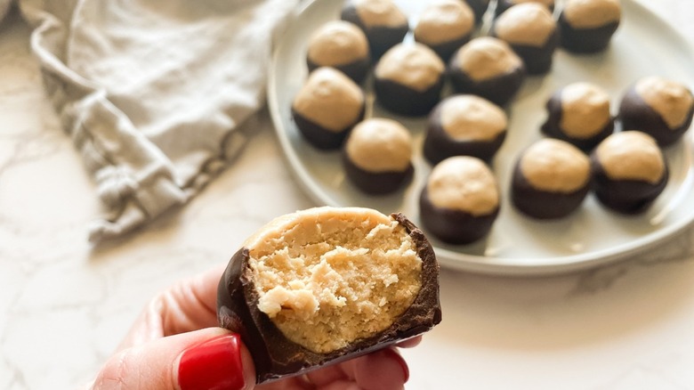 A woman holding a buckeye cookie.