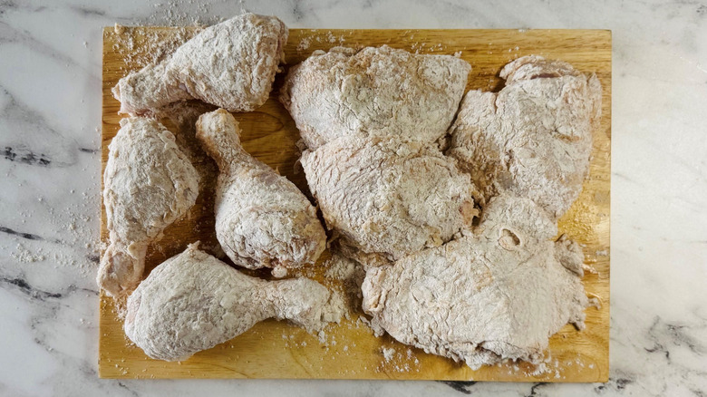 Breaded chicken pieces on wooden board