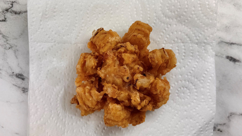 Fried whole onion on paper towels
