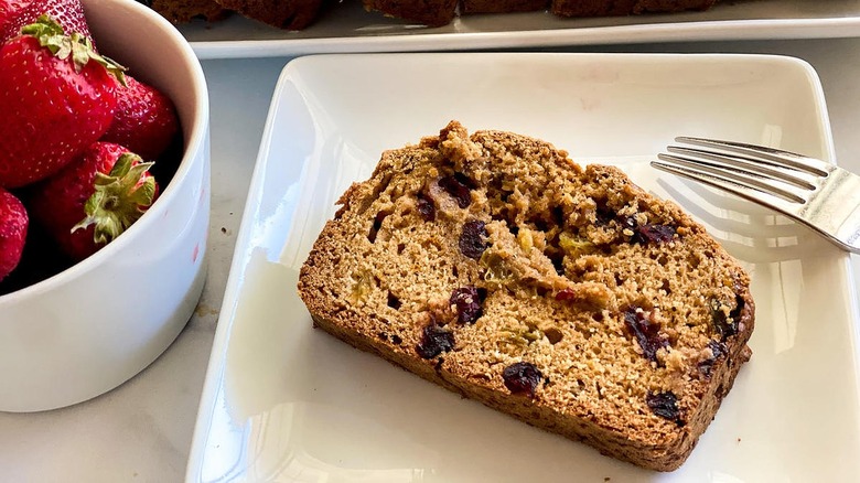 Fruit bread sitting next to a bowl of strawberries