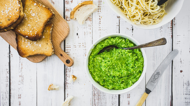 garlic scape pesto in bowl with toast and spaghetti