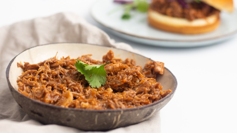 Pulled pork in serving dish with cilantro garnish