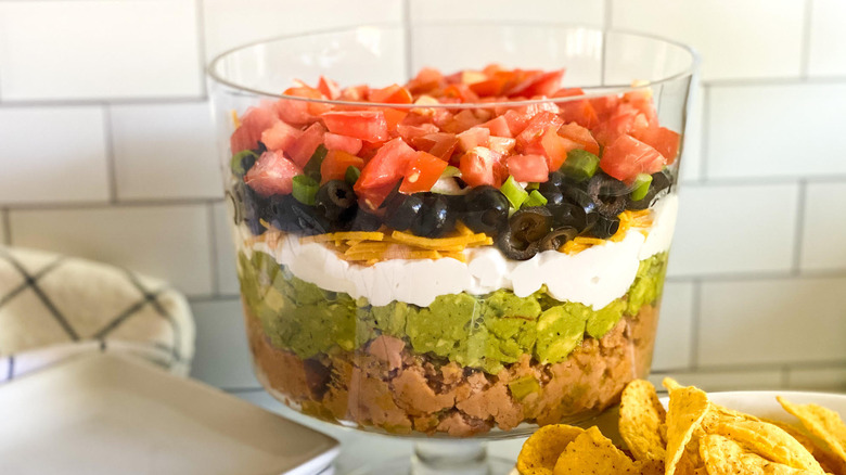 Easy Layered Taco Dip Recipe in bowl with tortillas on side