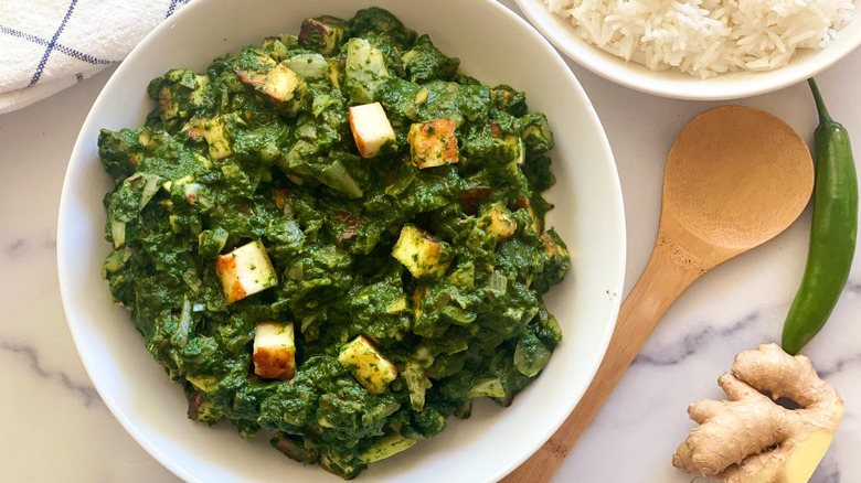 bowl of palak paneer with rice on side