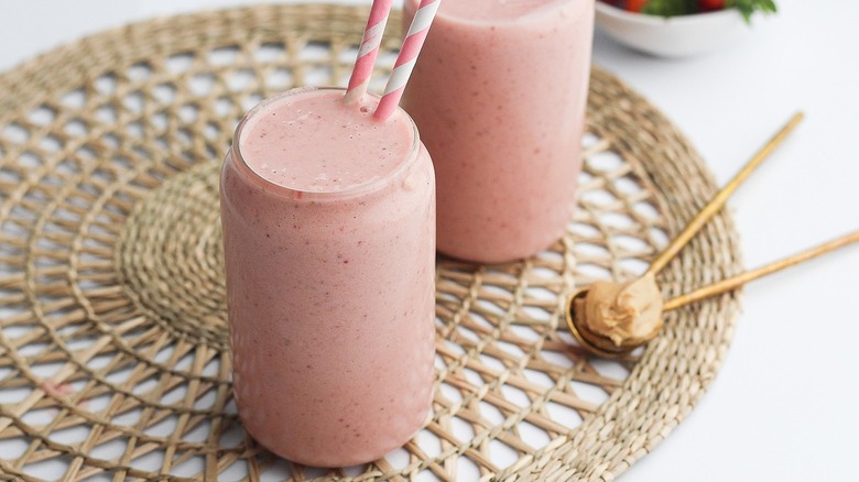 two pink smoothies with straws