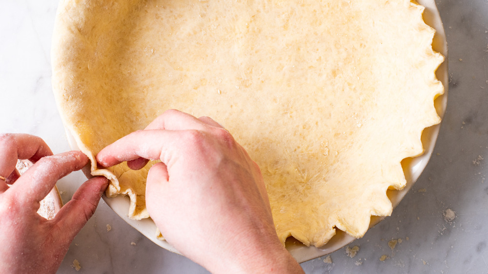 Hands crimping pie crust