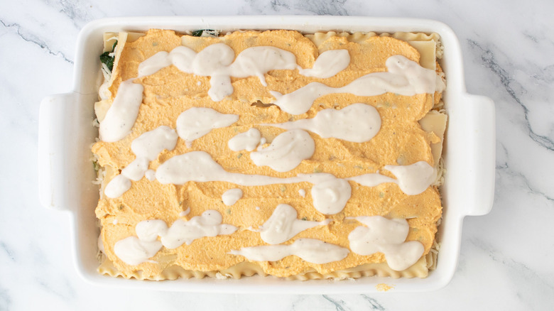 Pumpkin lasagna topped with dollops of Alfredo sauce