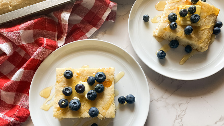 Sheet pancake slice topped with blueberry, second slice and napkin are visible