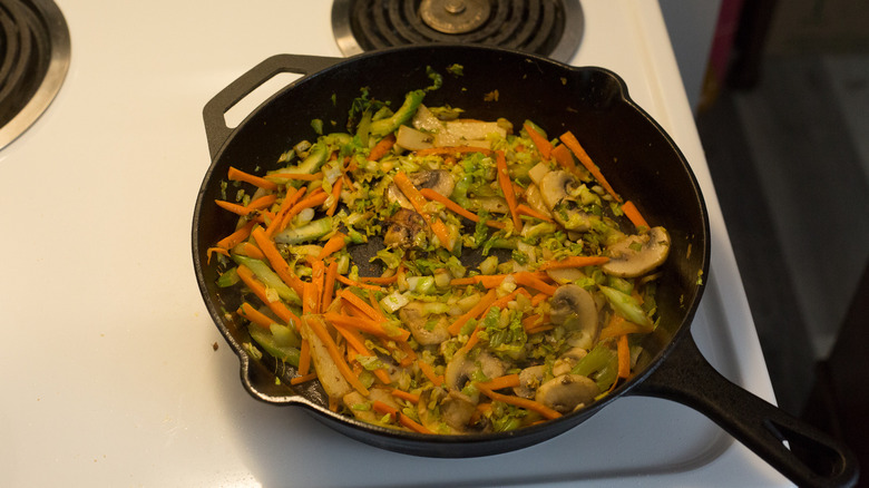 vegetables cooking in iron pan