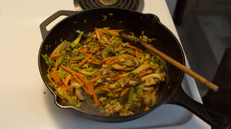 vegetables cooking in iron pan