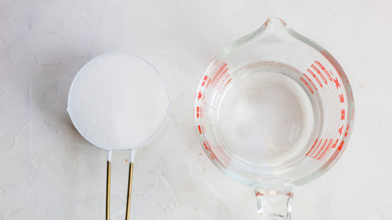 measuring cups of sugar and water