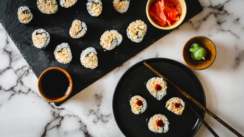 sushi on serving platters with wasabi, ginger and chopsticks