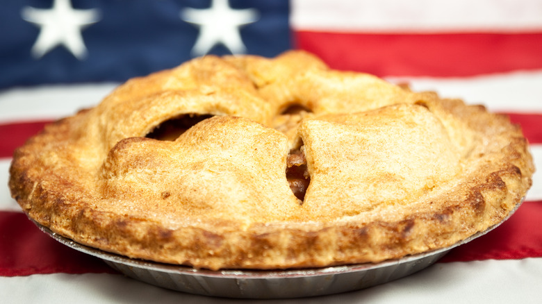 Baked double crust apple pie on American flag.