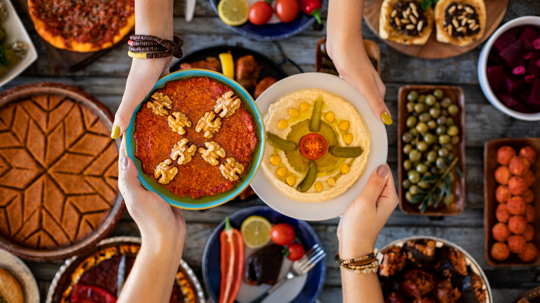 Two people sharing food over a full table